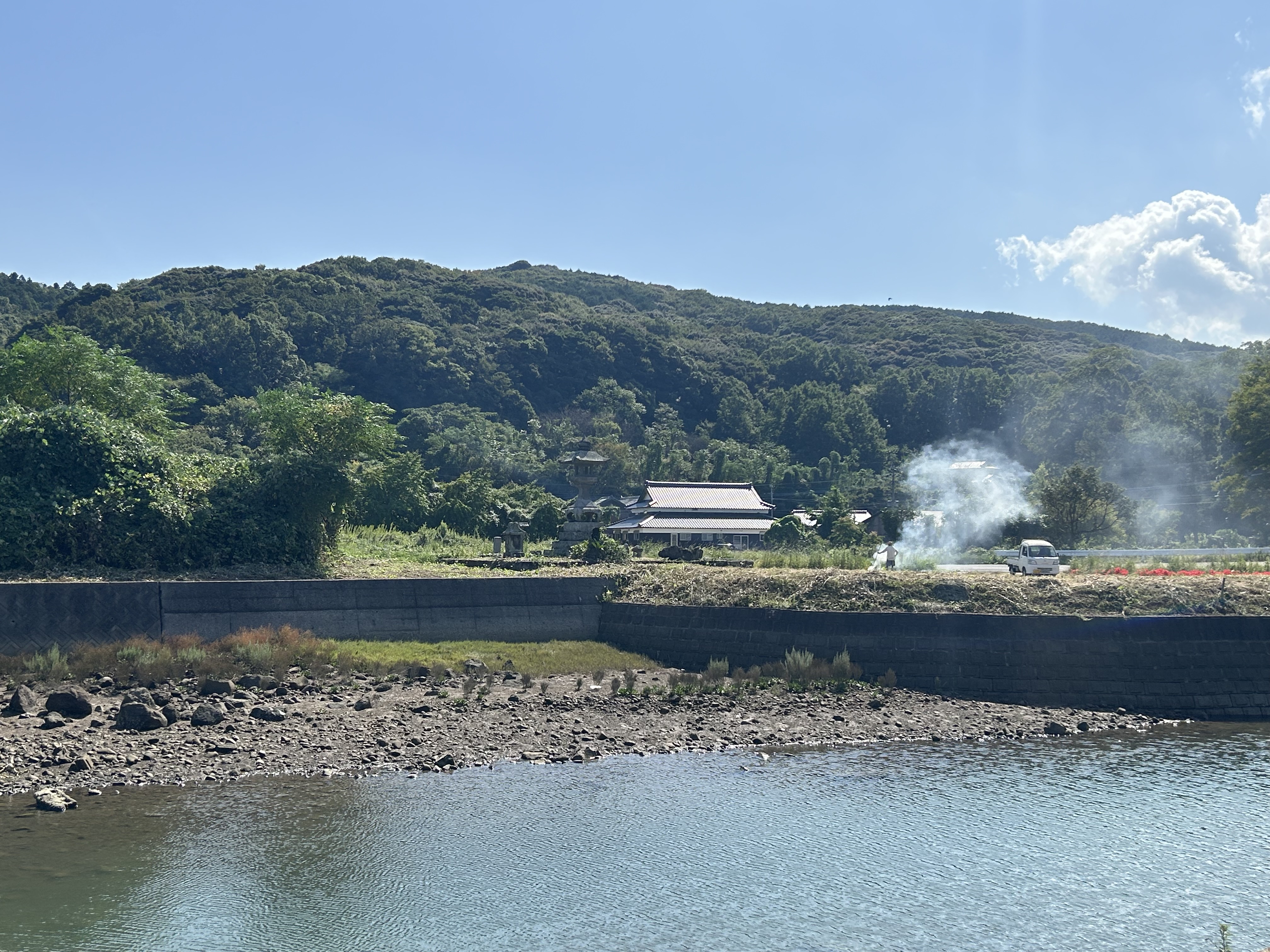 A renovated farmhouse among the hills, seen across the inlet at Kibe